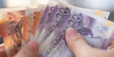 A person holding UK bank notes.