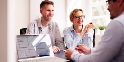 A couple happily talking with their financial planner.