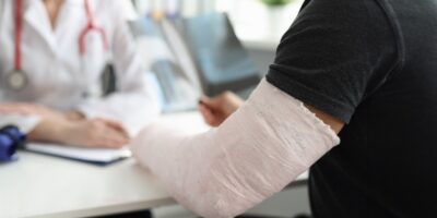 A man with a broken arm speaking with a doctor.
