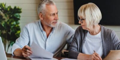 A mature couple talking and looking at paperwork together