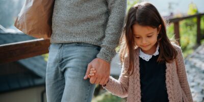 A mother and daughter holding hands.