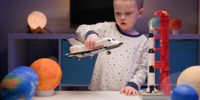 A boy playing with a toy rocket.