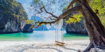 A beach with a swing hanging from a tree in Laos.