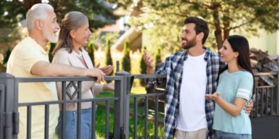 A young couple talking to their older neighbours.