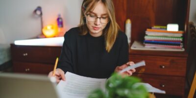 A young woman writing in a notebook.