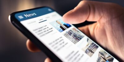 A person looking at a news feed on their phone.