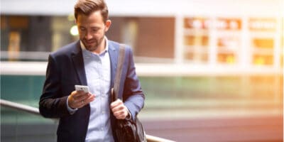 A man walking and using his smartphone.