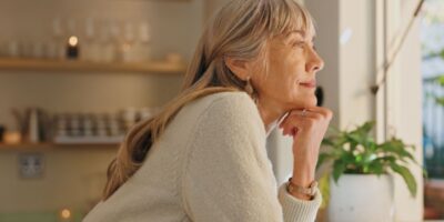 A woman looking out of the window at home.